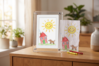 Little Picasso Frame showing a child's crayon drawing of a sun, house and dog, next to the original drawing